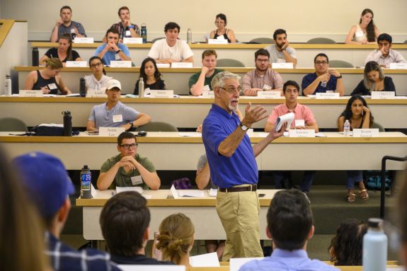 Man in blue shirt talks to a class