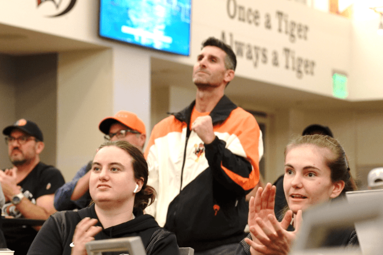 fans watch an athletic event broadcast in The Lair