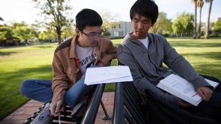 two students studying math together outside